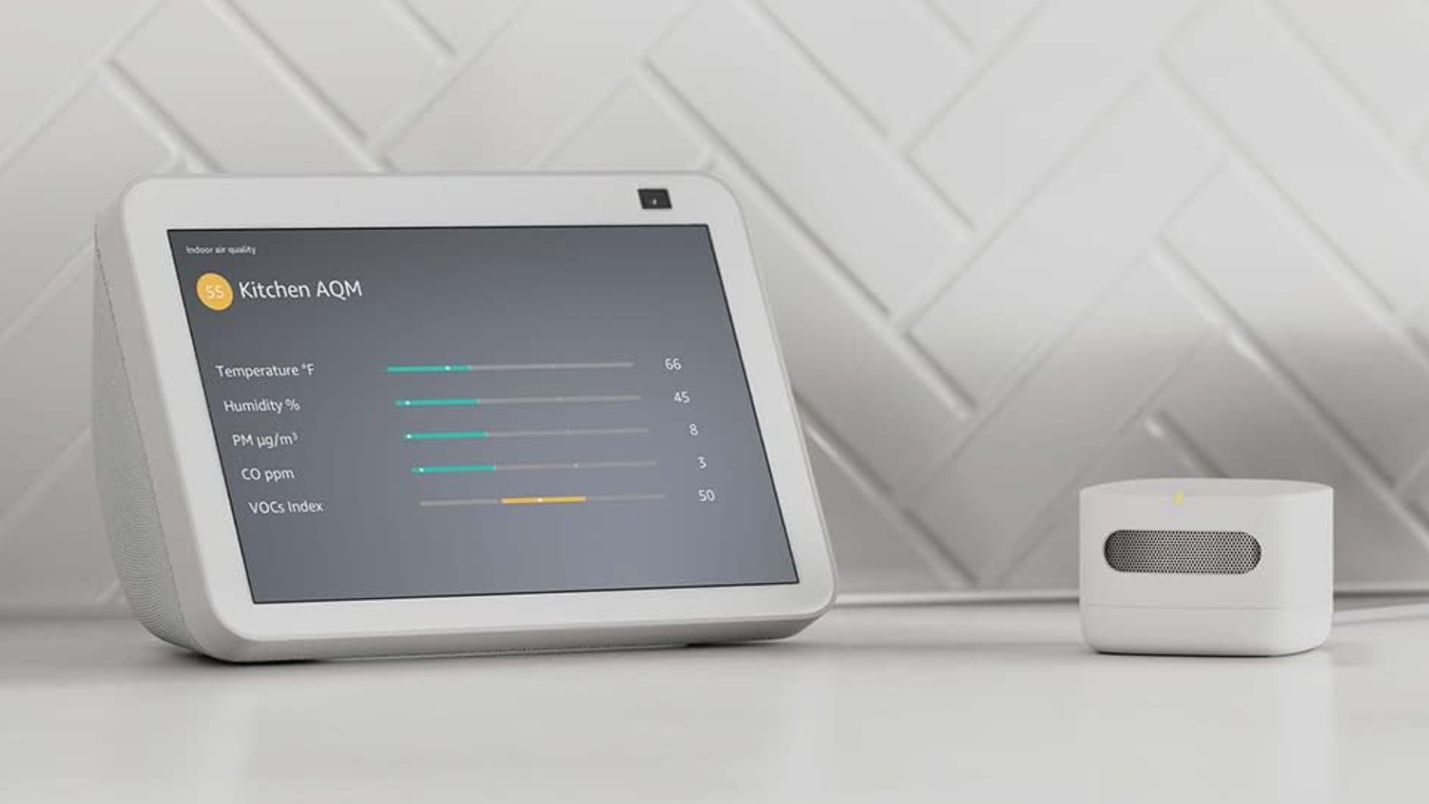 Amazon smart air quality monitor sitting on table with Echo Show displaying air score