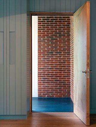 View through wooden door of a brick wall