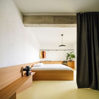 A bedroom divided by a curtain