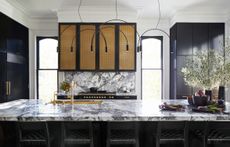 A kitchen colored blue, with tall cabinets that go all the way to the ceiling