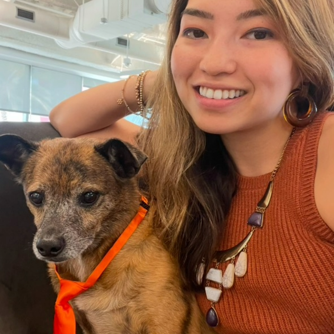 Sarah wearing a burnt orange top and Duke wearing an orange tie