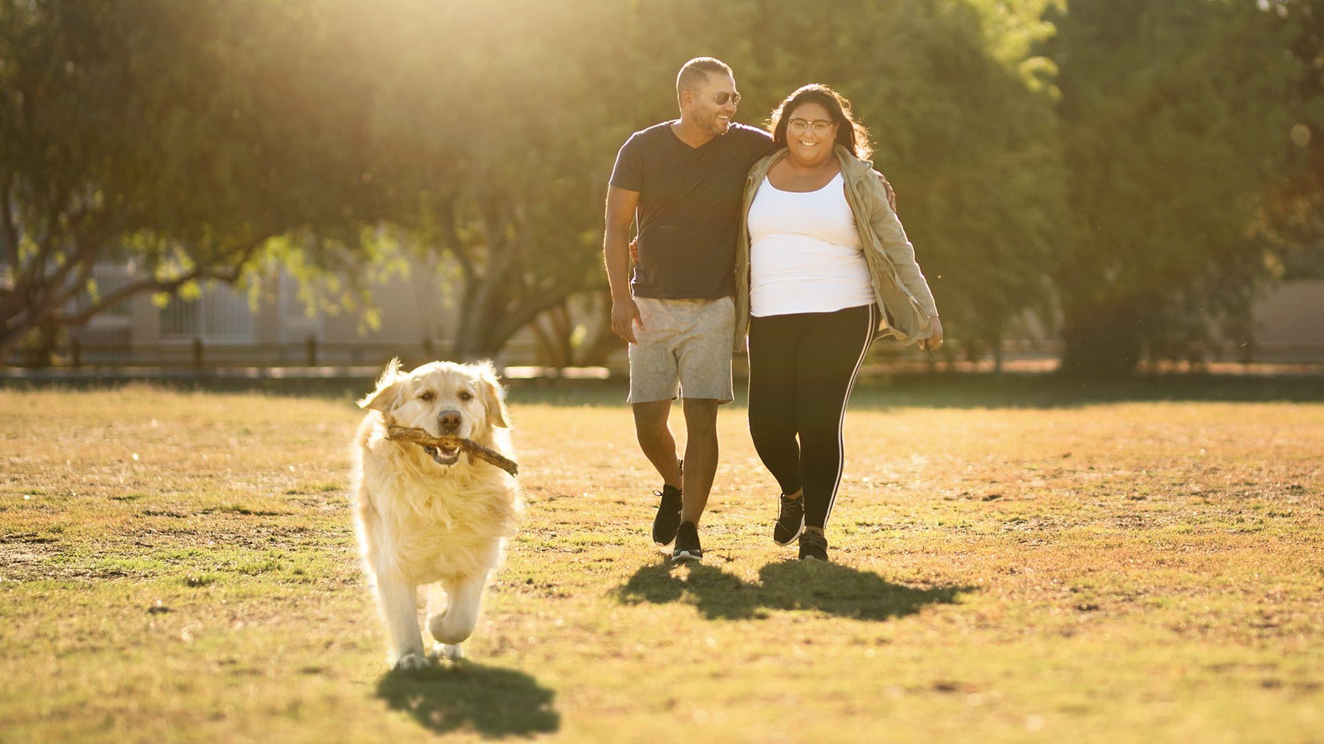 Couple walking with dog making use of dog walking tips