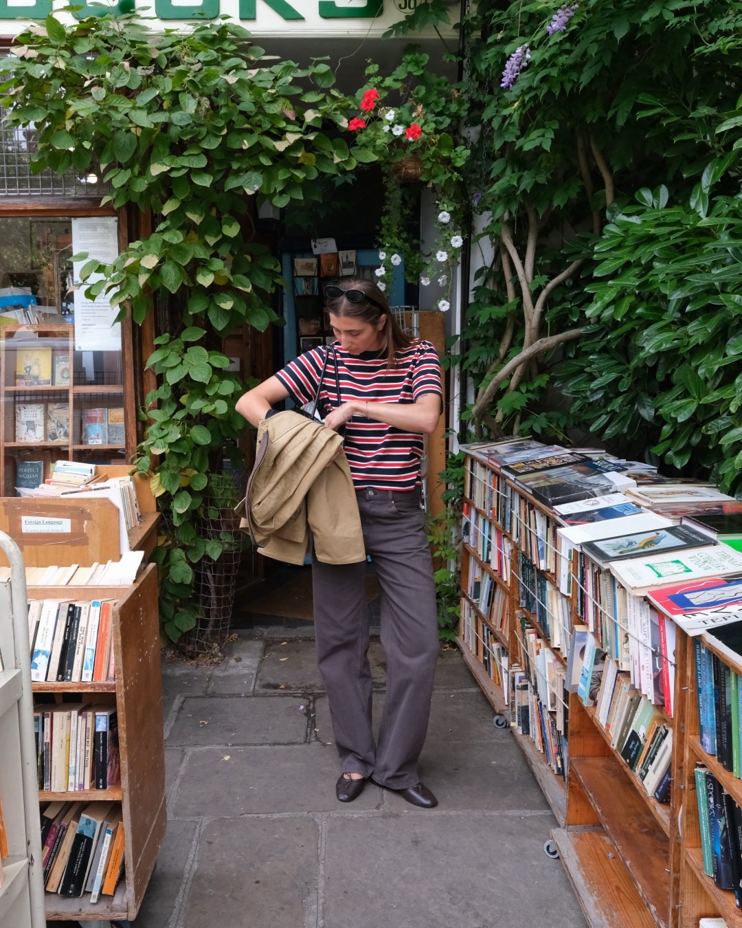 Influencer @poppyalmond wears brown jeans with brown leather ballet flats and a striped t-shirt.