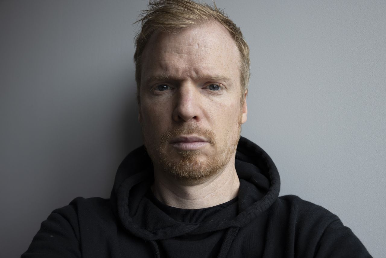 A self portrait against a plain gray wall taken with the Canon RF 35mm F1.4L
