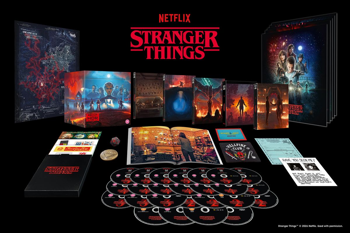 A screenshot of the Deluxe Edition of Stranger Things: The Complete Series, showing multiple discs, a book, box artwork, and other materials
