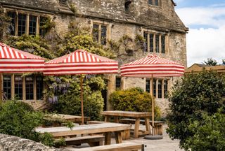 Red and white stripe parasols in front of a Cotswolds stone building