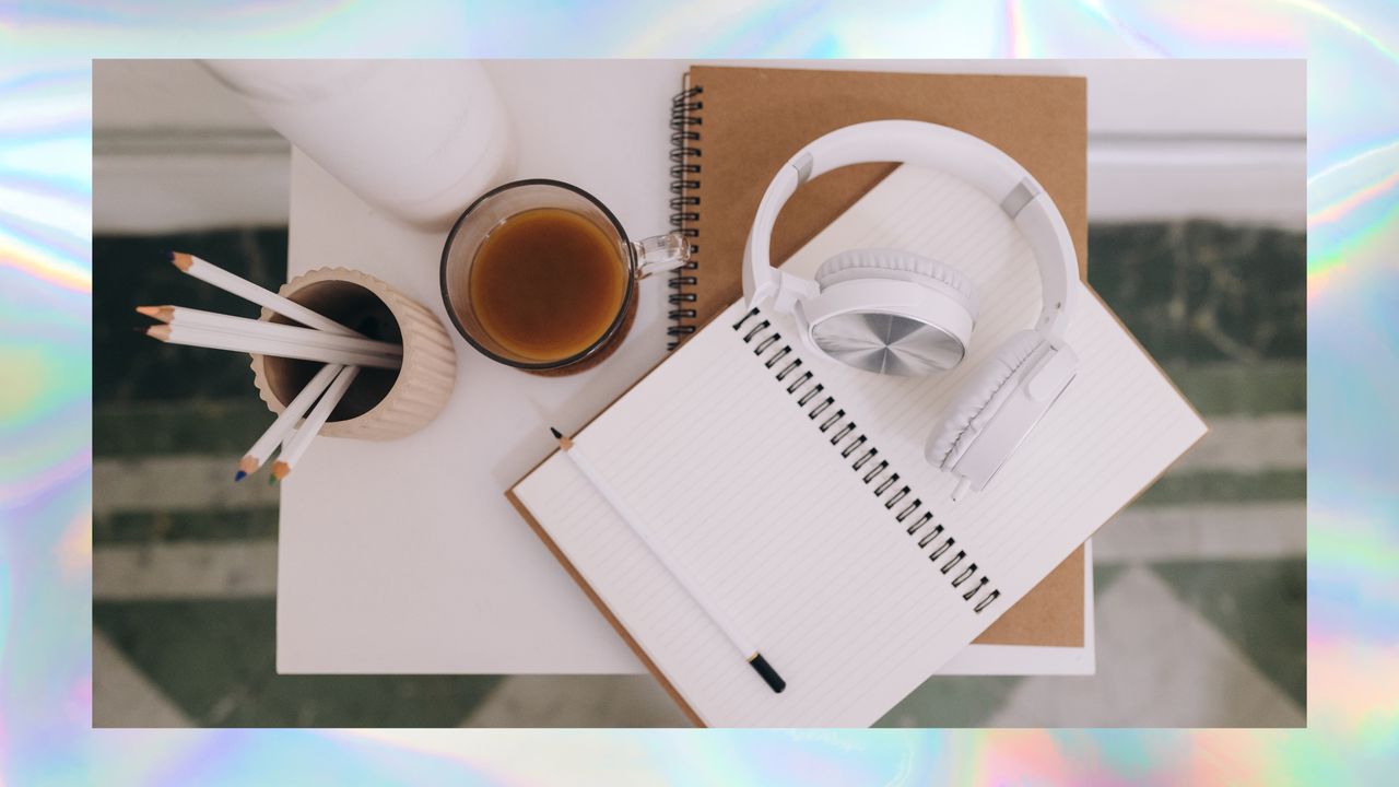 Desktop with headphones, coffee, and notebook