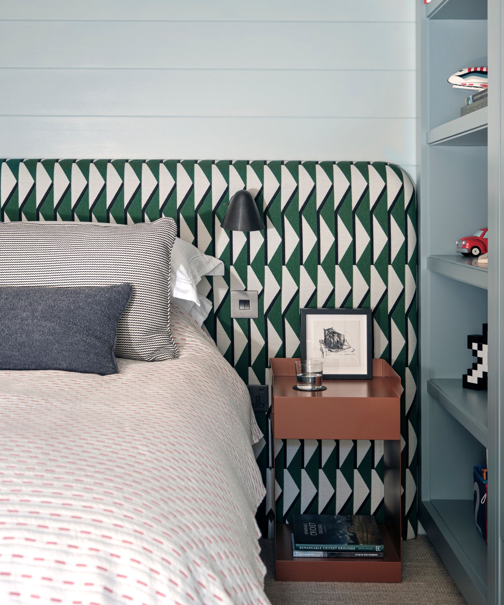 bedroom with green and white geometric pattern headboard