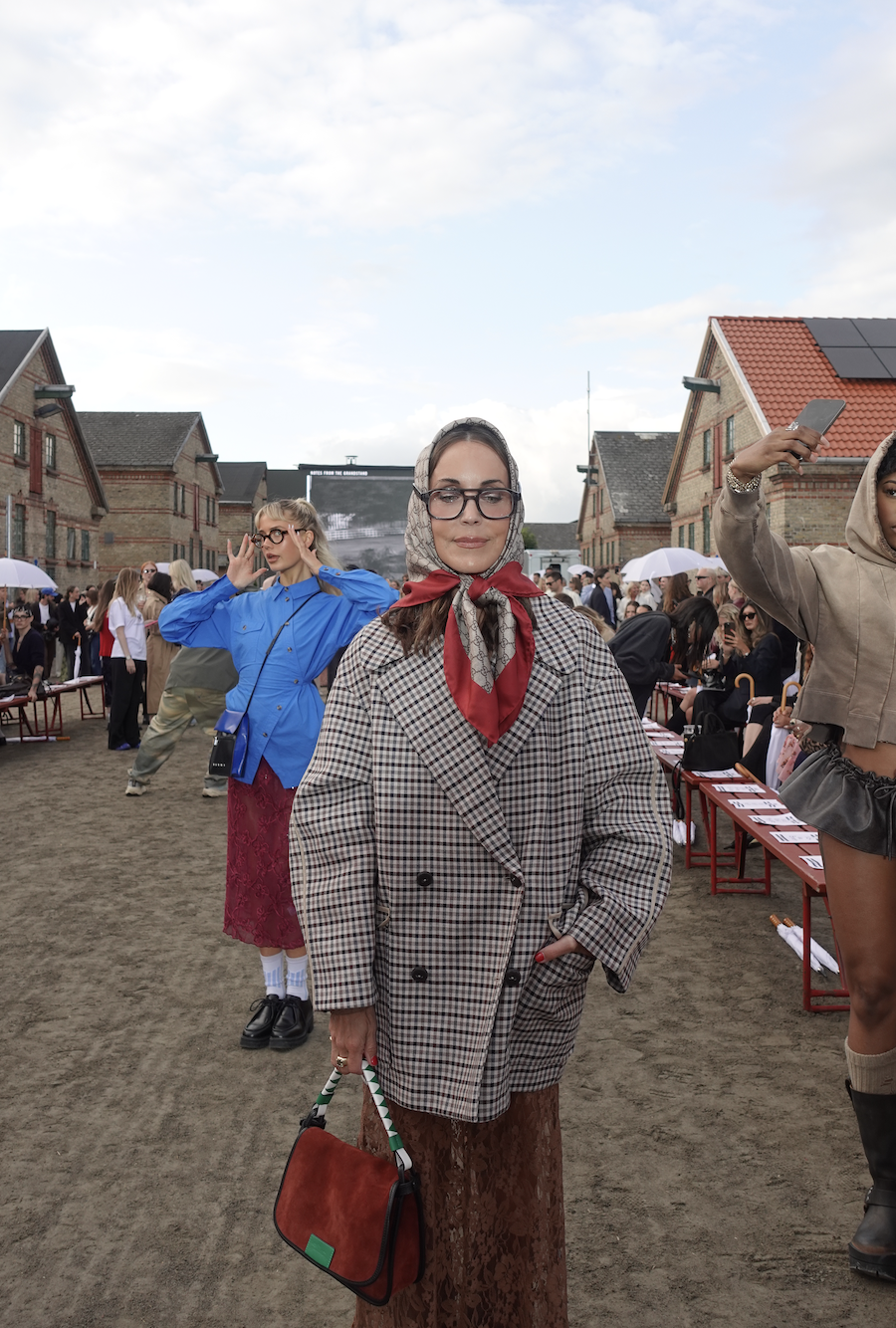 Larissa Mills wearing a silk gucci scarf around her neck, a plaid jacket, and brown lace skirt