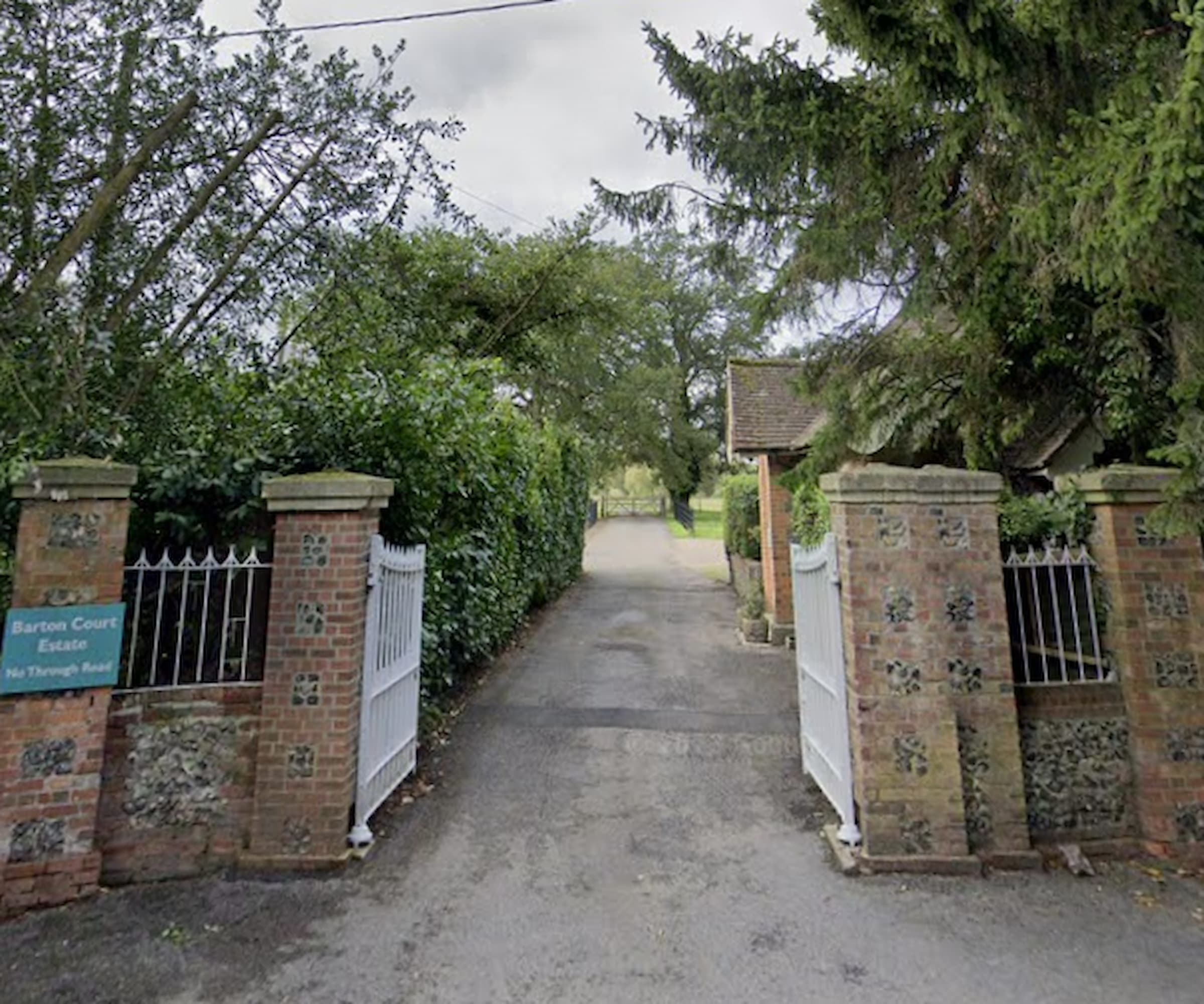 A pair of white gates next to a brick wall