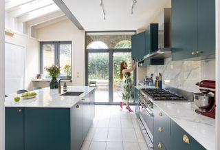 A kitchen extension with bespoke blue fittings and marble countertops 