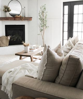 Corner fireplace, taupe fabric sofa in Scandi living room with wooden coffee table