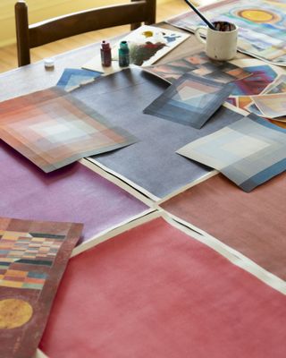 A series of paintings on a table by Calico Wallpaper founder Rachel Cope