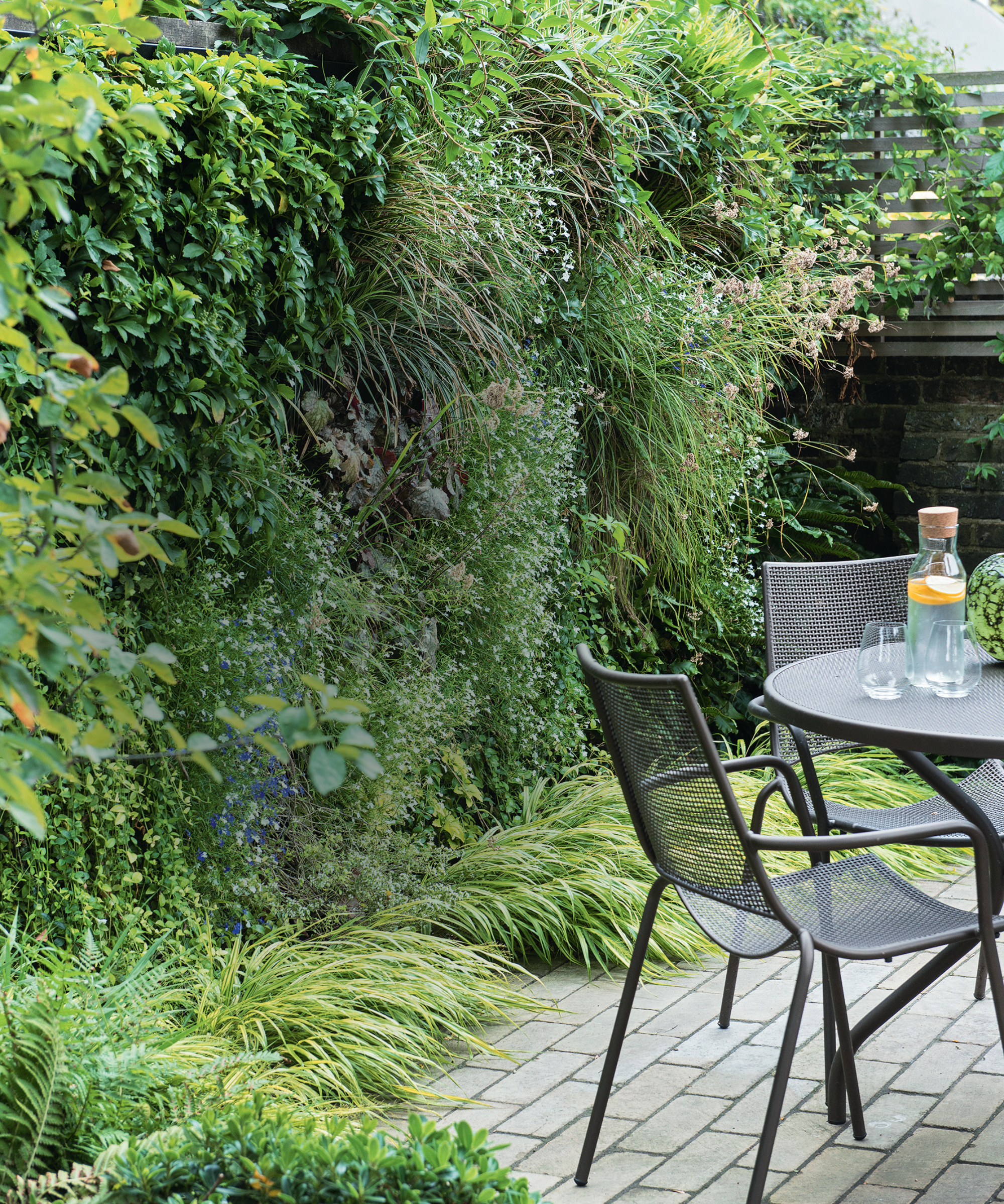 Planting used to edge patio and blur the garden boundary to make a backyard look bigger