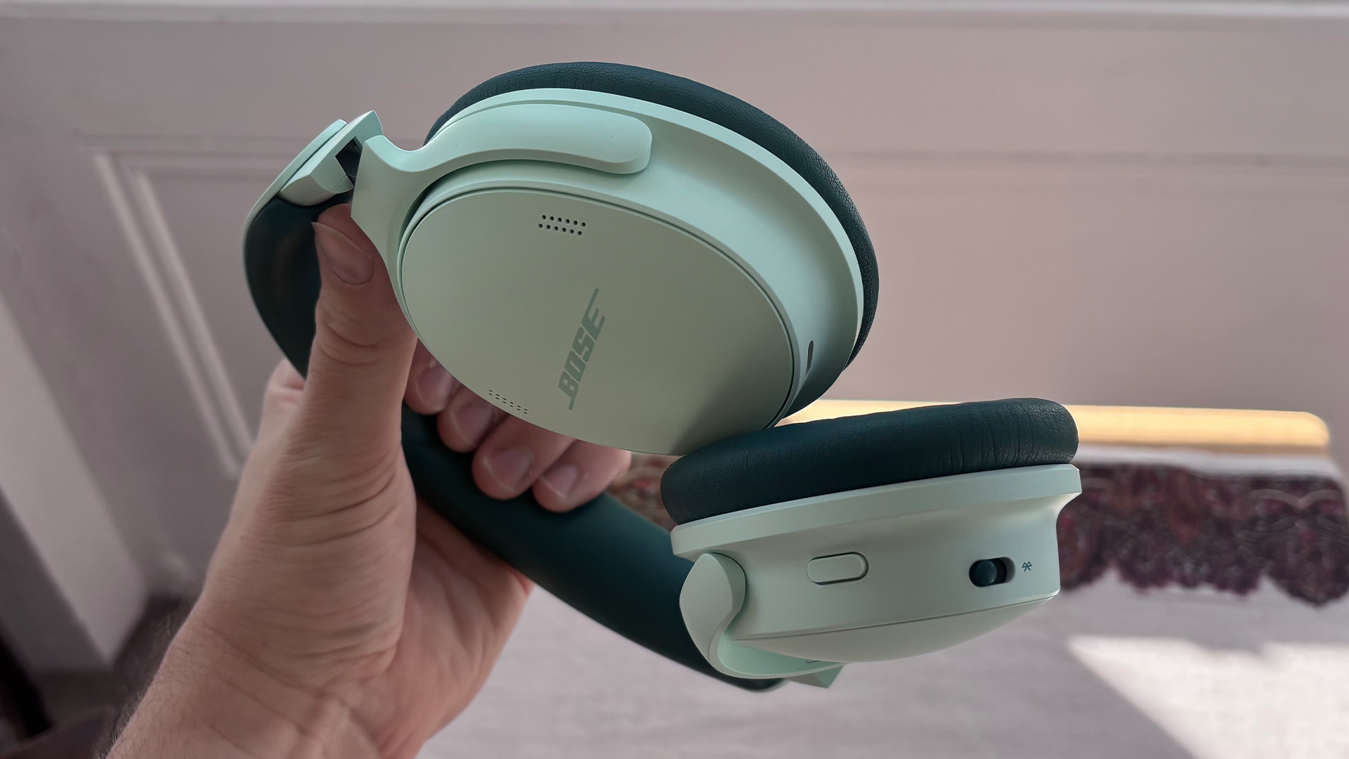 Bose QuietComfort Headphones (2nd Gen) over-ear headphones in mint green held in hand