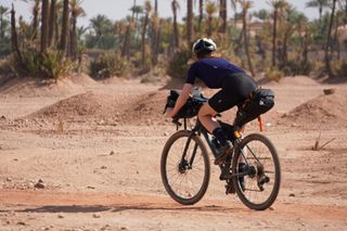 Image shows Anna cycling in the palm grove area on the outskirts of Marrakech in Morocco