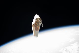 The debris shield that once protected NASA's Alpha Magnetic Spectrometer from micrometeoroid impacts floats away from the International Space Station after two astronauts removed it and flung it into space during a spacewalk on Nov. 15. European Space Agency astronaut Luca Parmitano used special tools to remove 13 screws and 10 fasteners to release the debris shield, after which NASA astronaut Drew Morgan jettisoned the shield, tossing it toward Earth to burn up in the atmosphere. This was the first of four spacewalks that these two astronauts are conducting to repair the ailing particle detector experiment, which was not designed to be serviced by astronauts in orbit, making these some of the most challenging spacewalks ever.