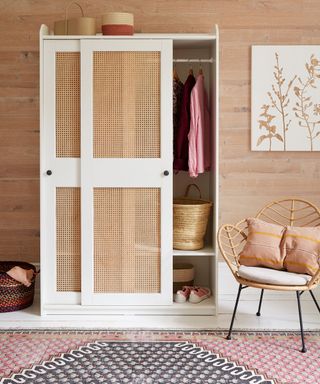 Cane fronted sliding wardrobe with hanging rail inside and storage baskets on top