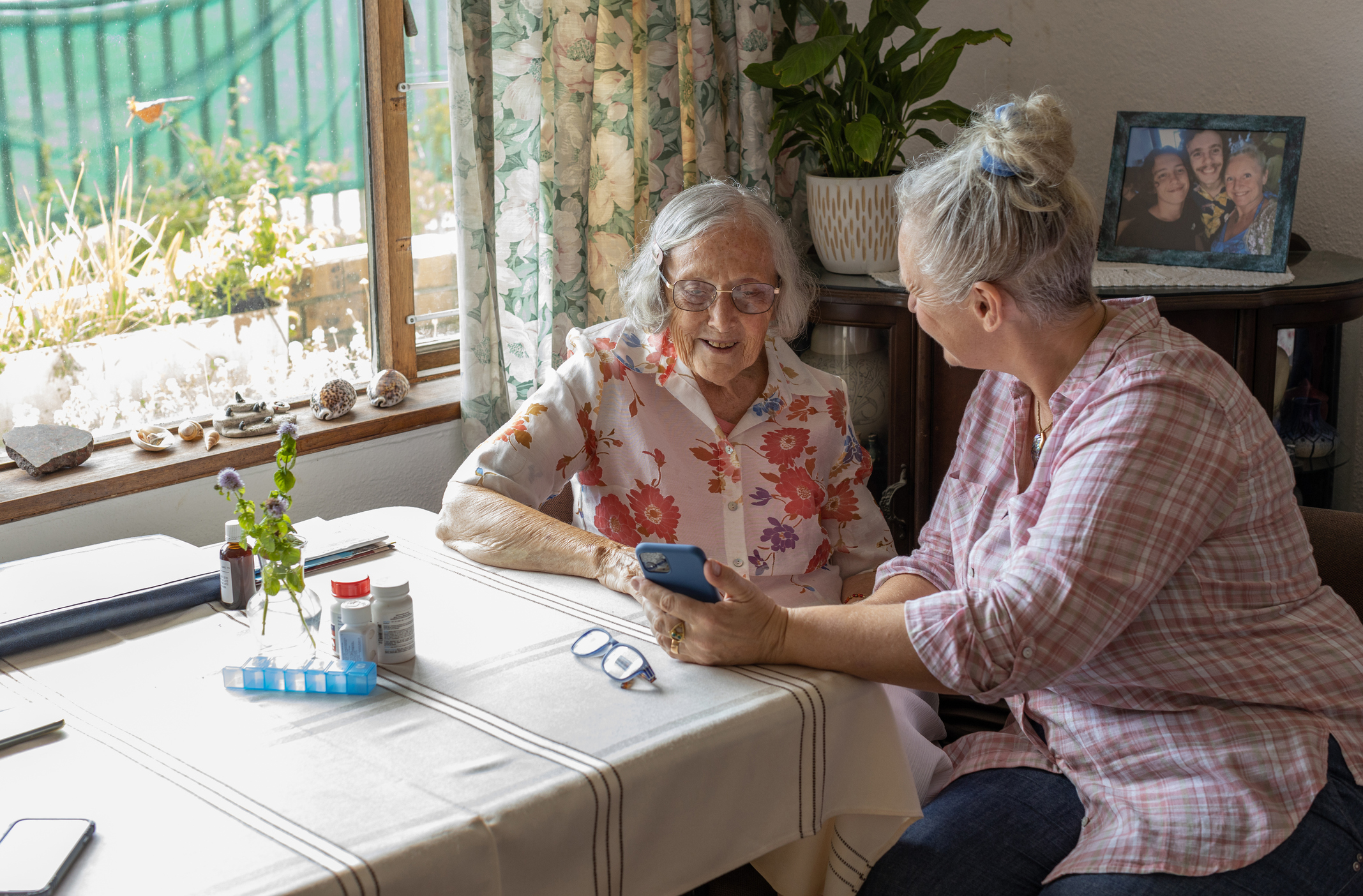 Person with their unpaid carer sit at table.