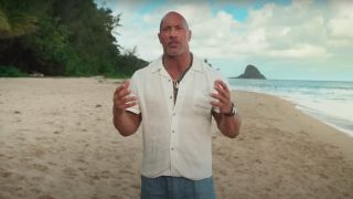 Dwayne Johnson talks on the beach during the live-action announcement for Moana.