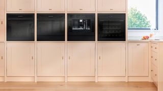 built in ovens in pale full height kitchen units