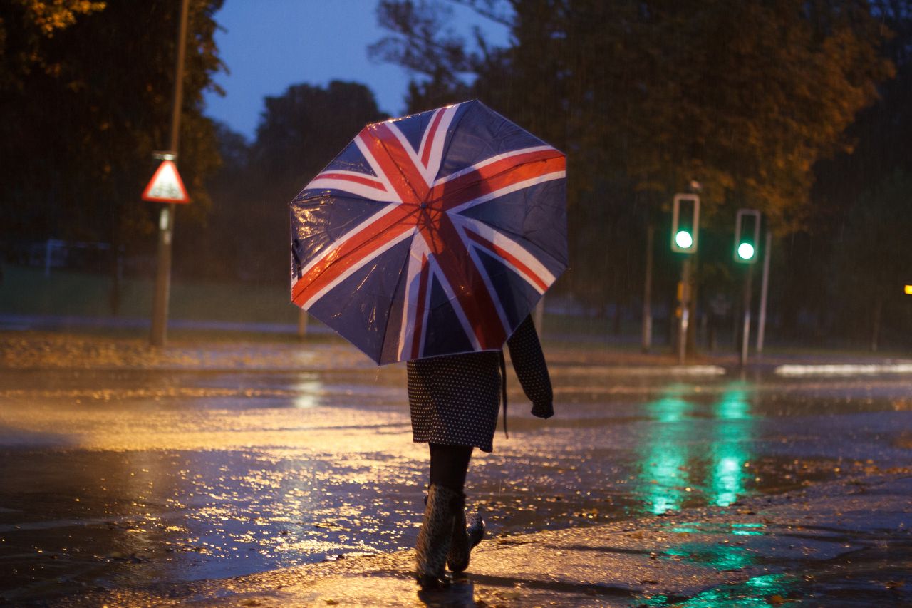 person with union jack umbrella in storm