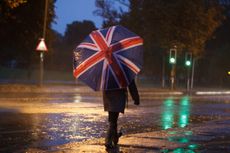 person with union jack umbrella in storm