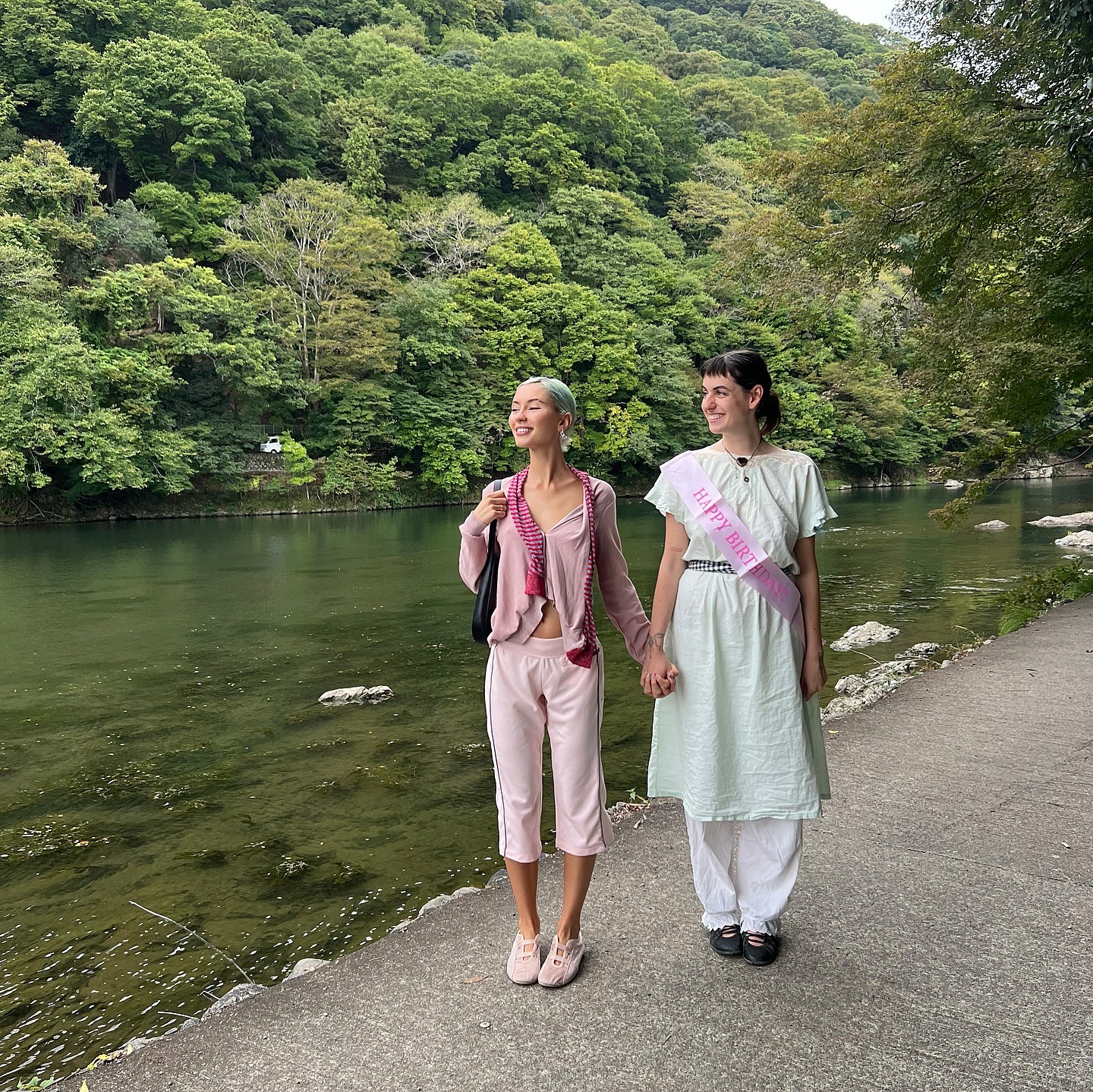 Model Iris Law wearing capri track pants in pink with low-profile trainers and a pink cardigan.