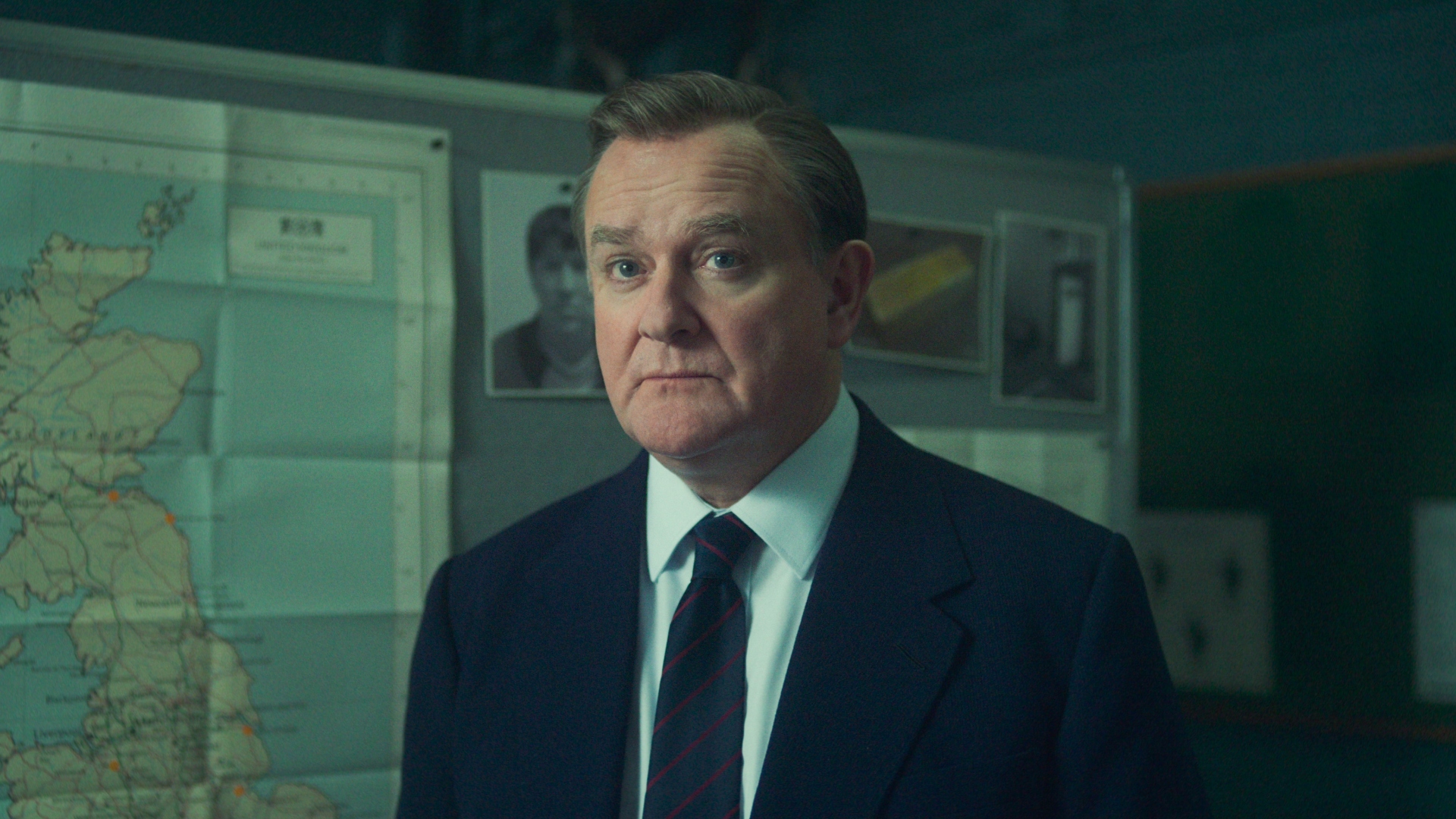 Boyce stands in front of a board in The Gold season 2