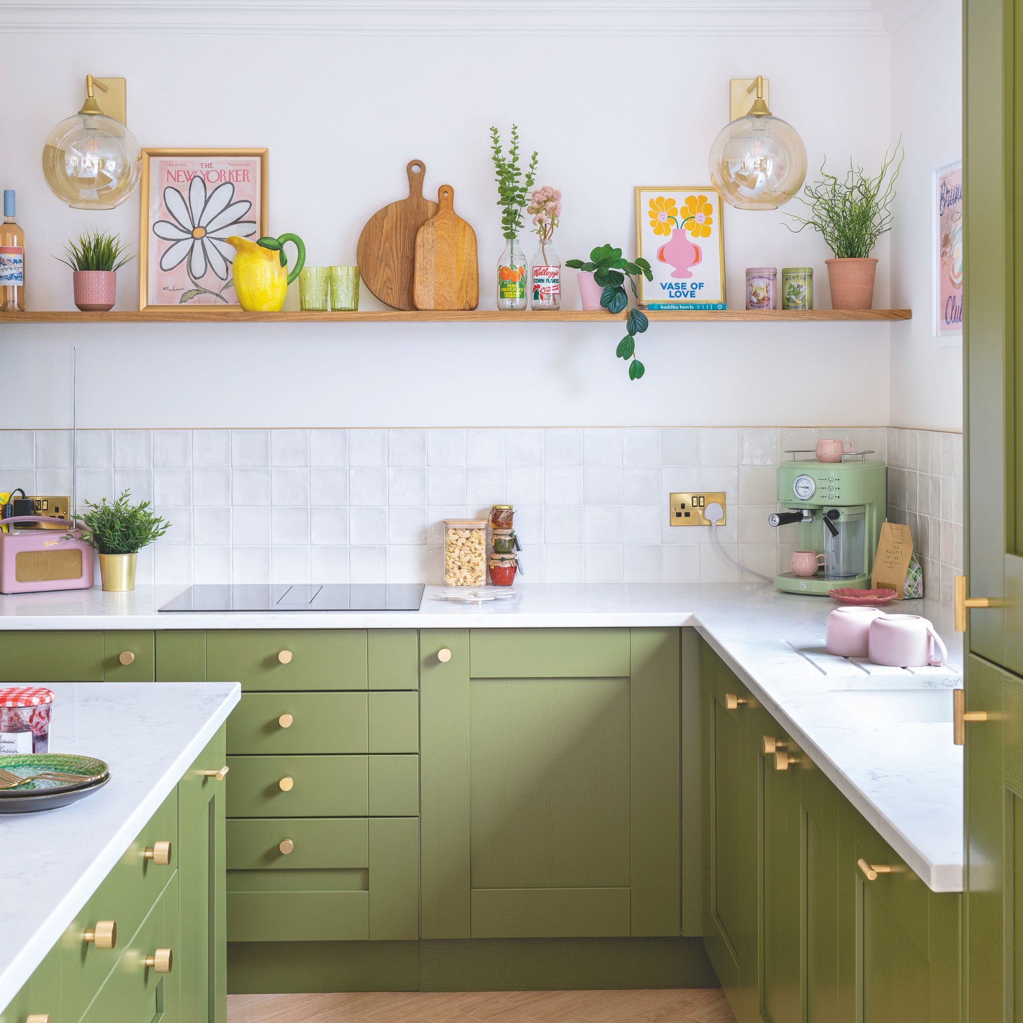 White painted and tiled kitchen with green cabinets, and open shelving above