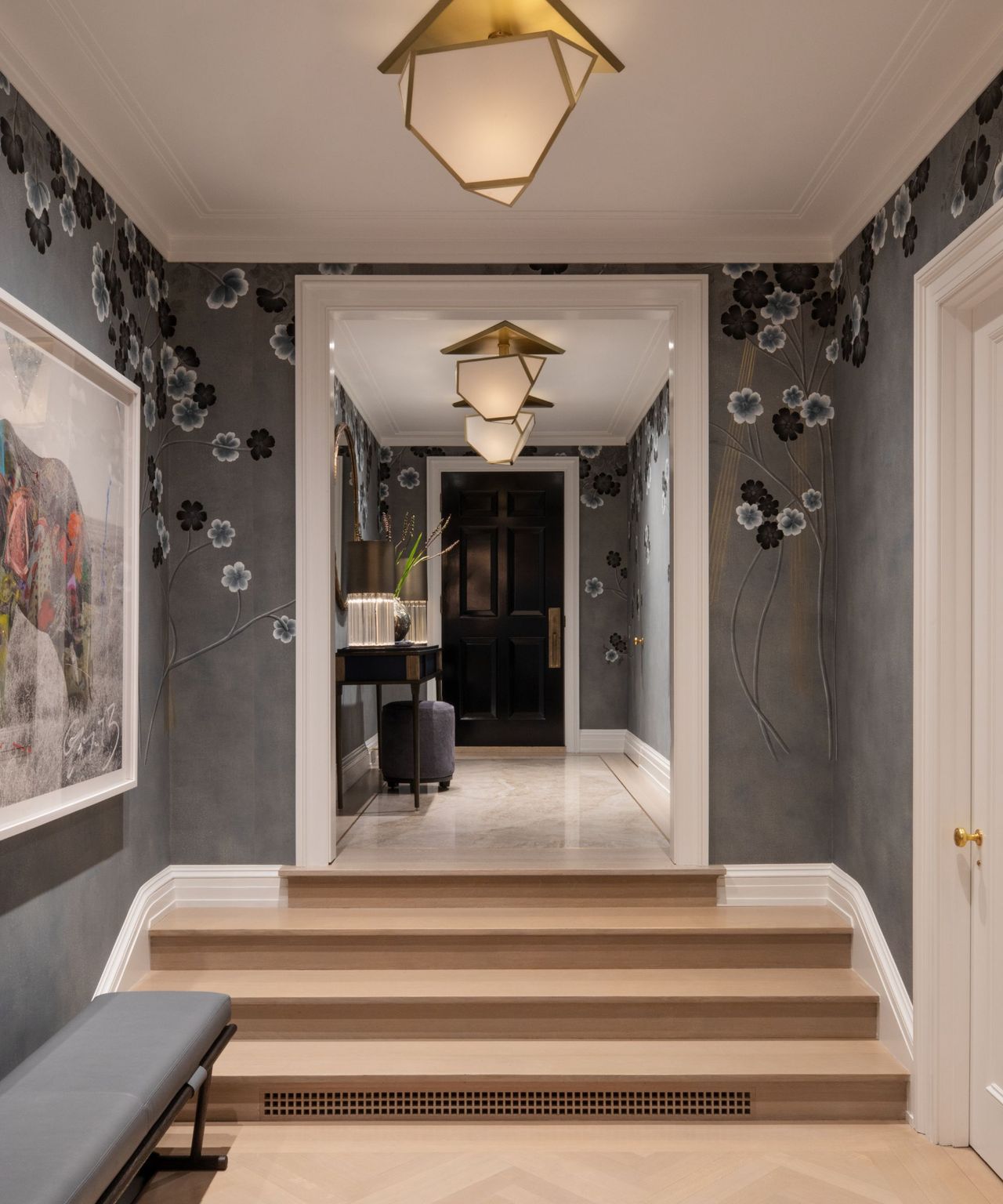 A gray entryway with floral wallpaper and four steps