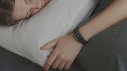 best sleep tracker: Woman asleep wearing Xiaomi Mi Band 4
