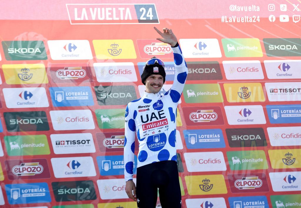 Team UAE's Jay Vine celebrates on the podium wearing the best climber jersey after the stage 20 of the Vuelta a Espana, a 172 km race between Villarcayo and Picon Blanco, on September 7, 2024. (Photo by ANDER GILLENEA / AFP)