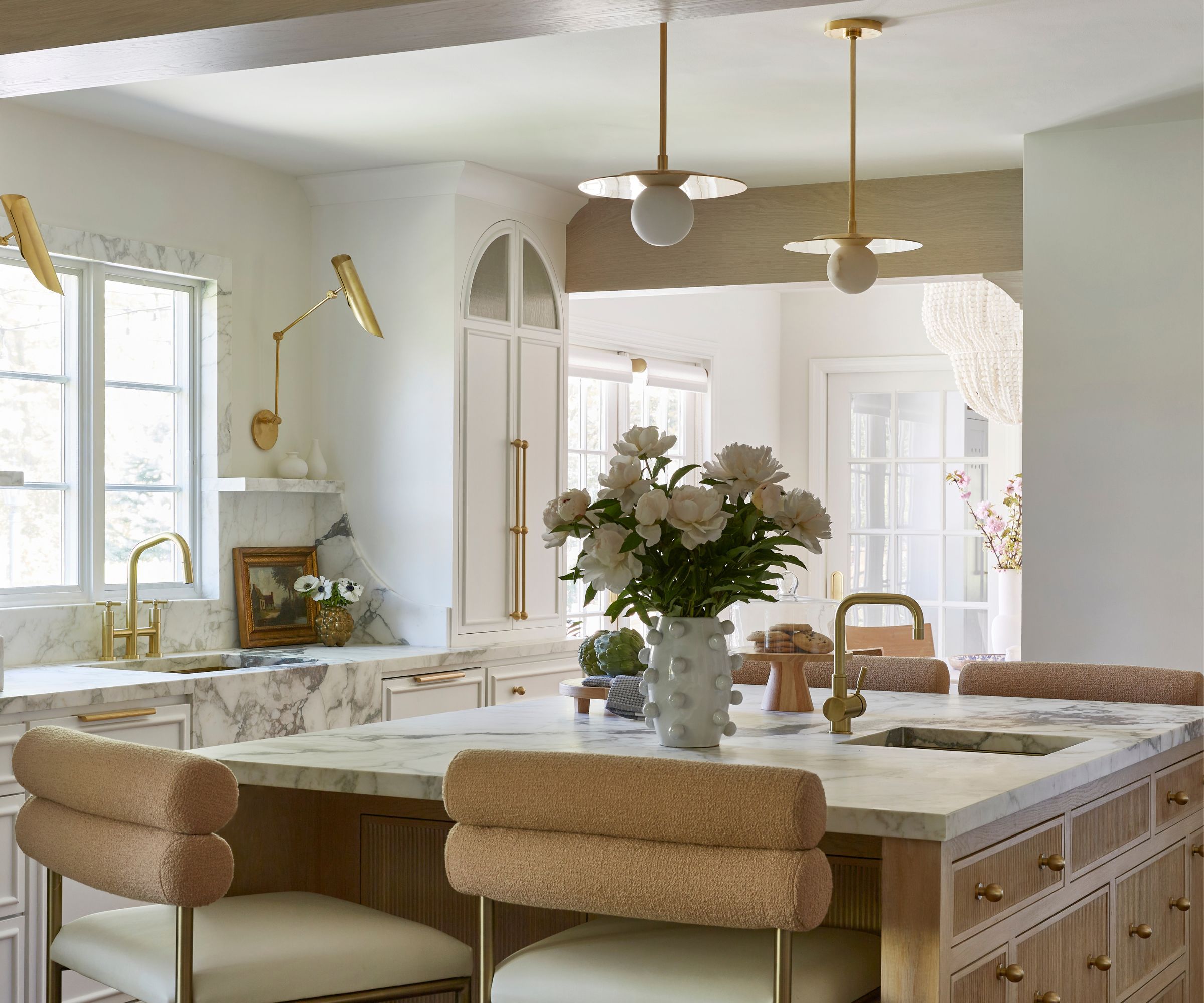 A small white kitchen with a wooden island and brass details