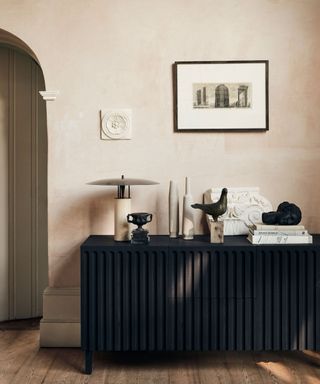 contemporary sideboard with fluted front, table lamp and objects displayed above