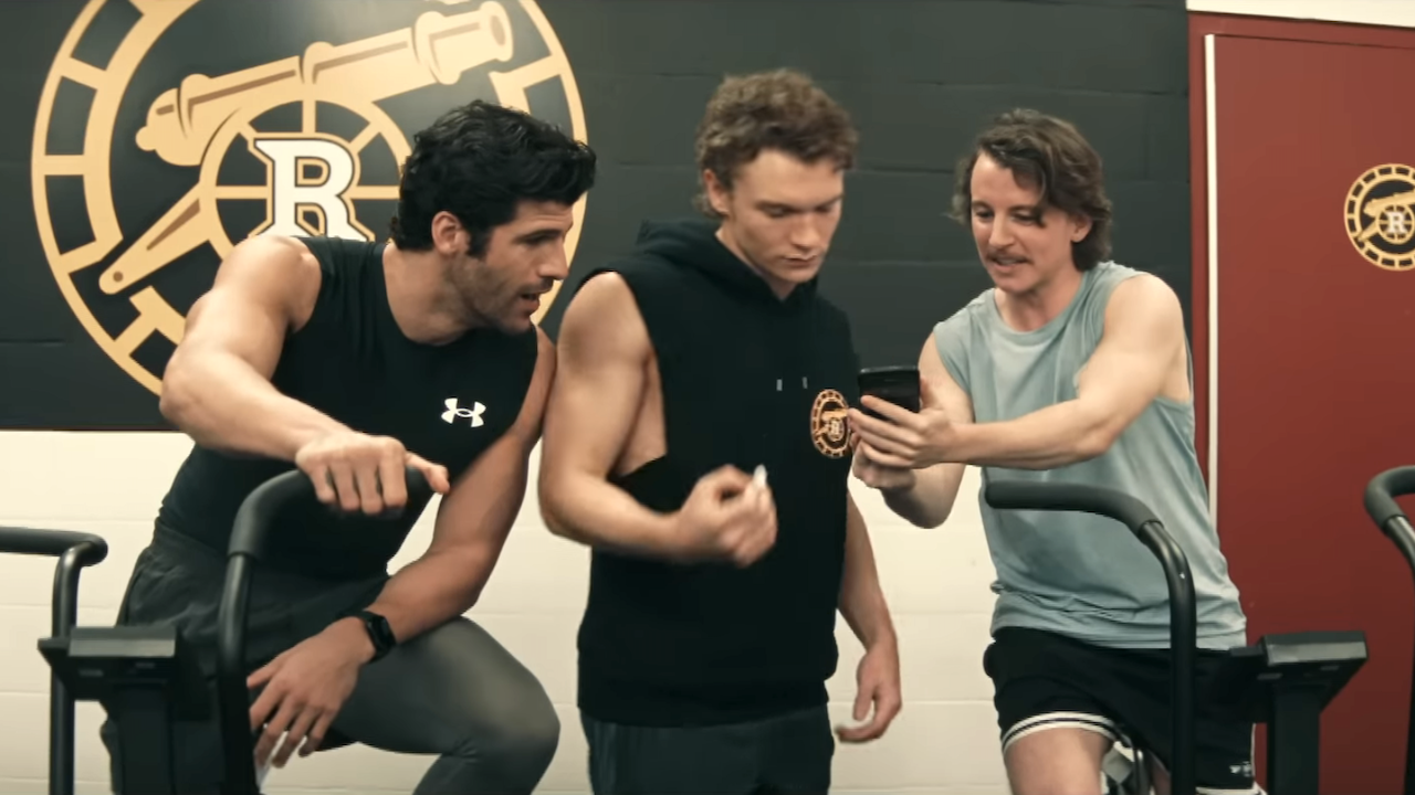 ilya and his teammates looking at a cell phone on heated rivalry