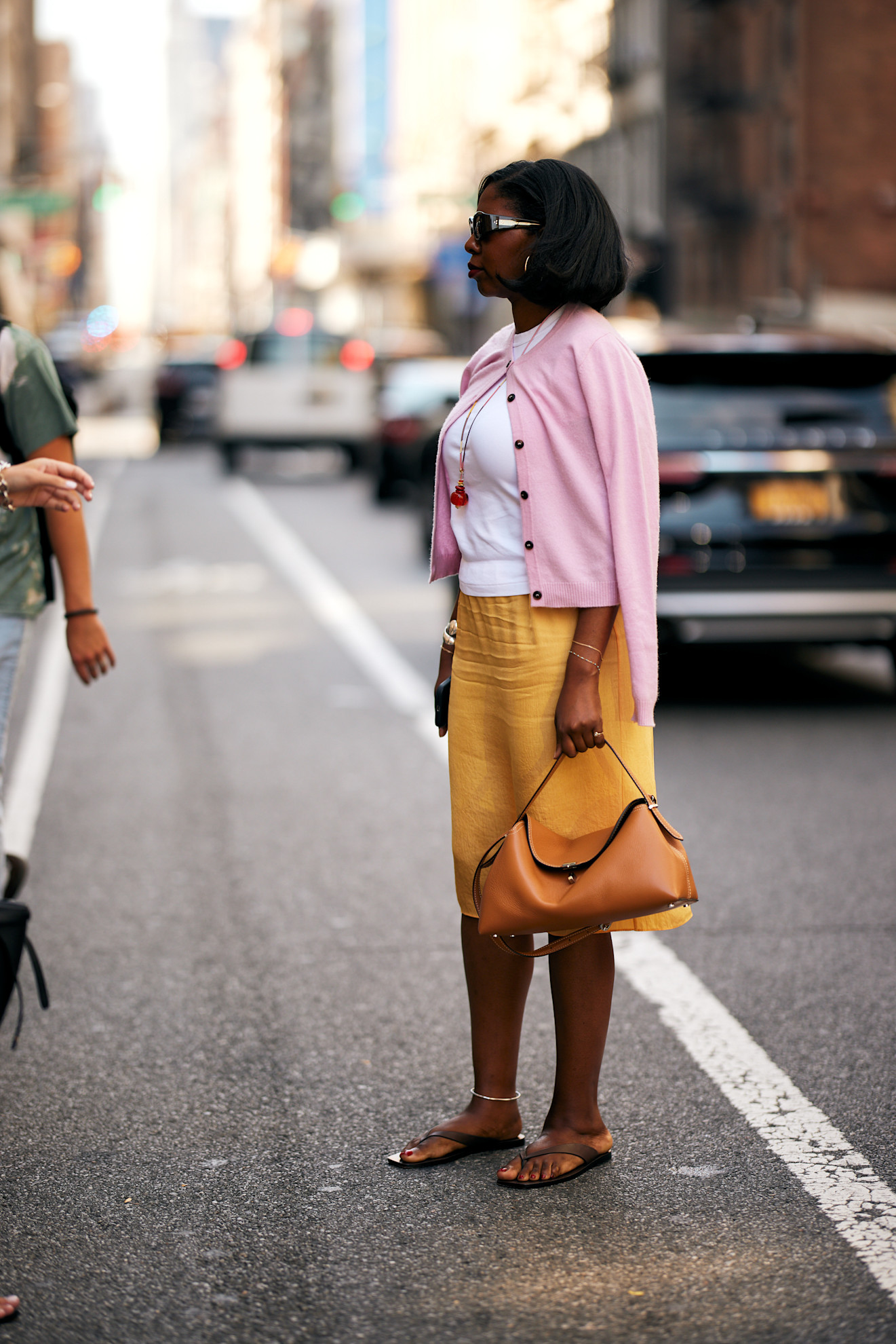 wo,an wearing pink sweater and orange skirt