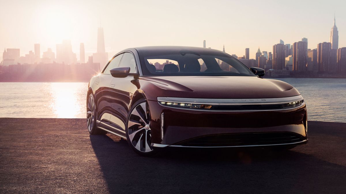 Lucid Air parked next to a river with a city skyline in the background