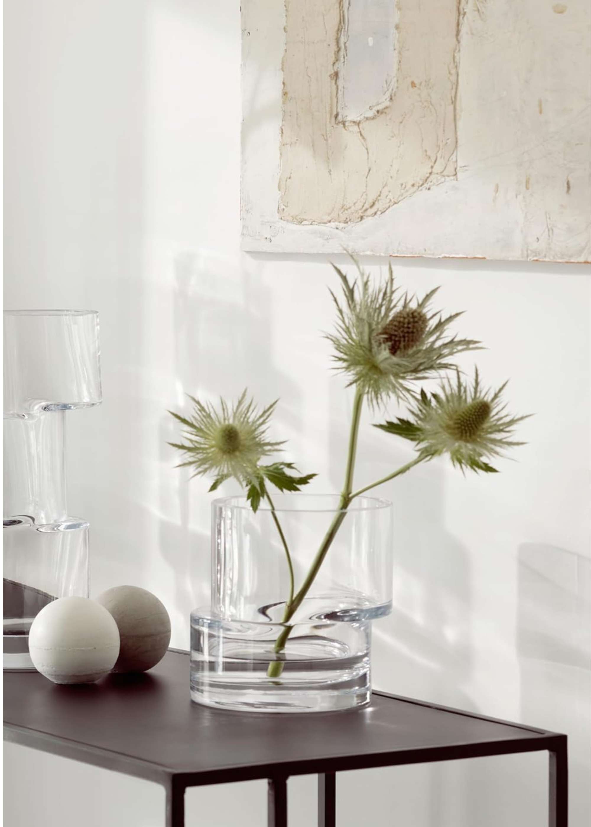 LSA vase filled with thistles on a console with another vase and decorative items