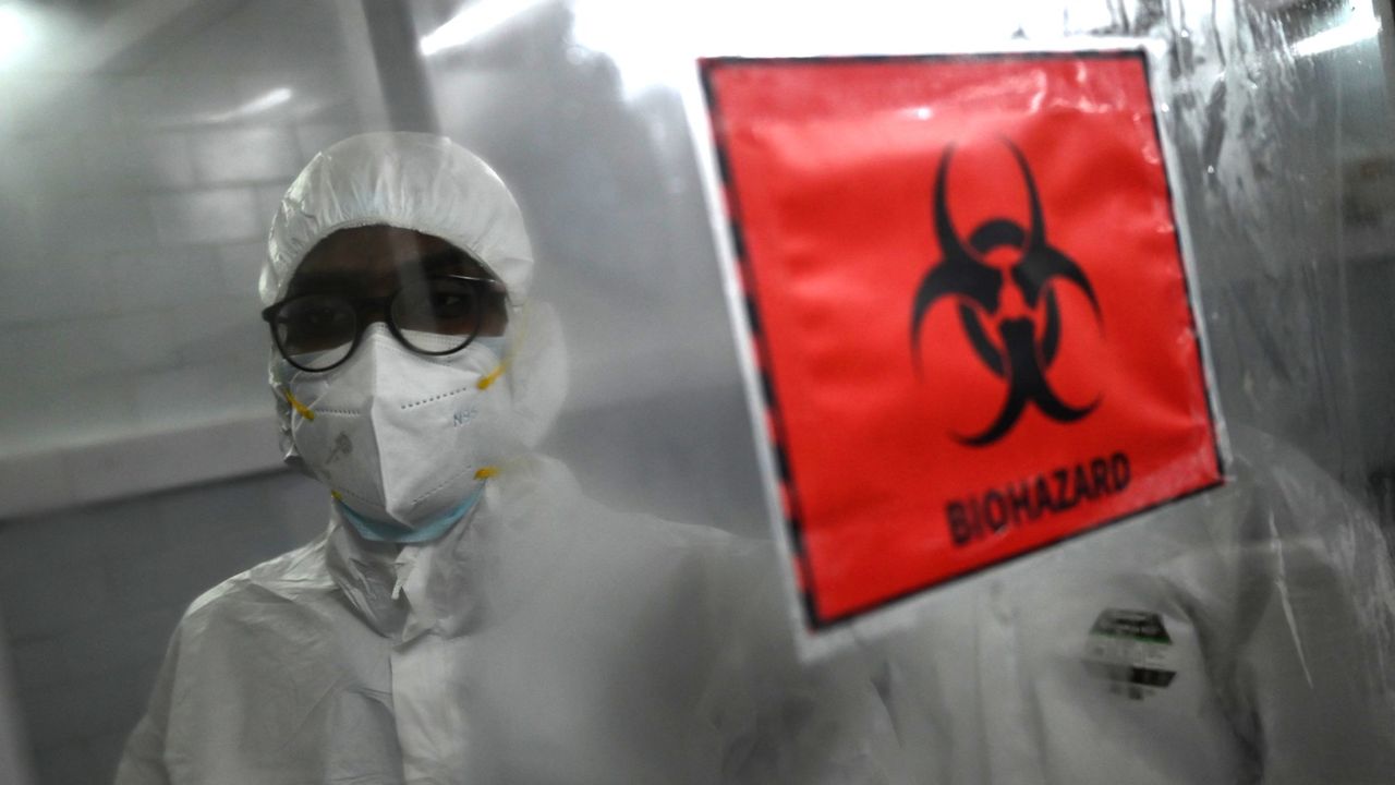 A scientist wears protective equipment behind a biohazard area in Chennai, India, in 2022.