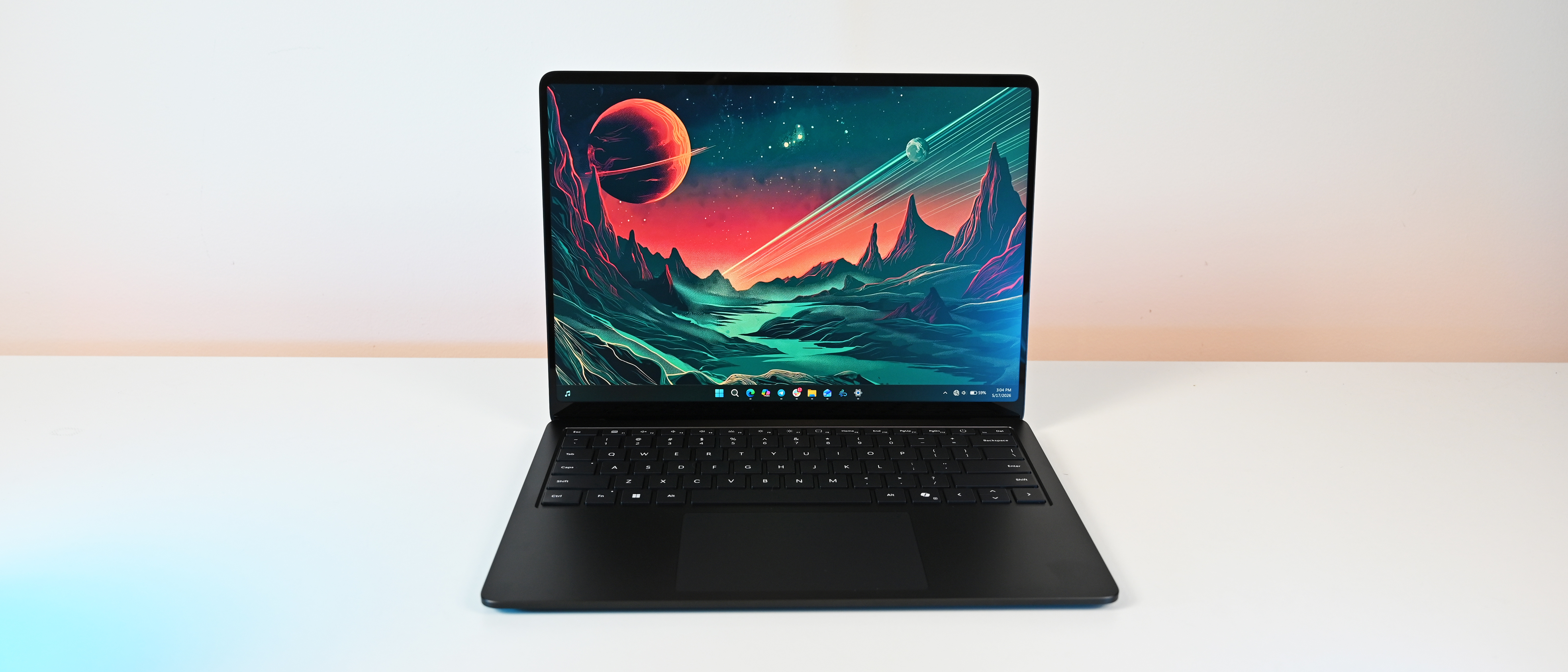 A sleek, on a white surface displays a vibrant, cosmic landscape wallpaper with planets and mountains, creating an adventurous and futuristic tone.