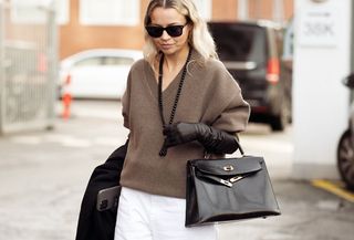 Woman in beige sweater and white jeans