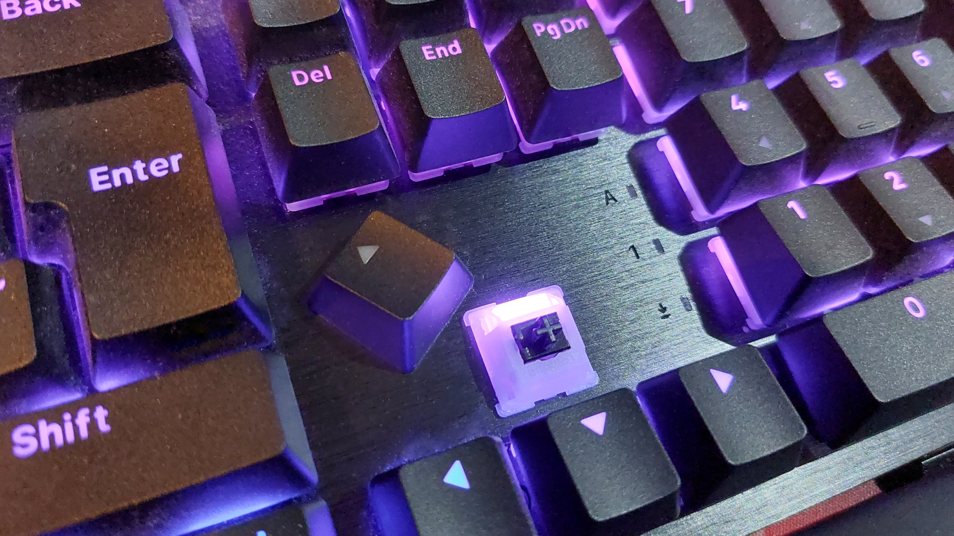 A photograph of a gaming keyboard on a wooden desk.
