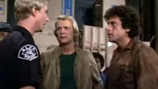 Paul Michael Glaser and David Soul in plain clothes talking to a uniformed officer in Starsky and Hutch.