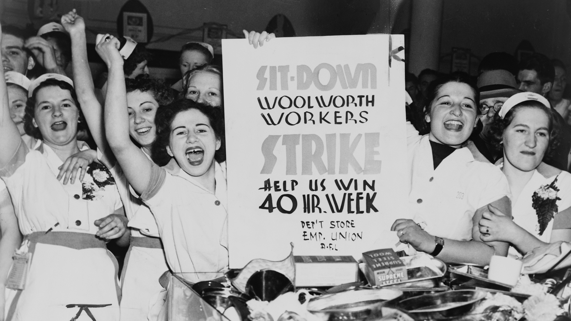 Female employees of Woolworth's hold a sign indicating they are striking for a 40-hour work week, in 1937.