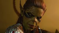 Baldur's Gate 3 screenshot showing Lae'zel, a Githyanki woman with olive green skin and tied-back red hair, smirking