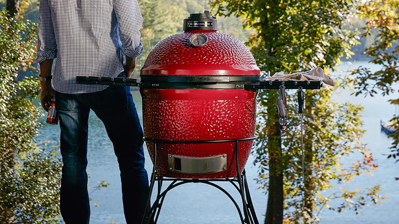 Kamado Joe Classic I grill in country setting with man standing nearby