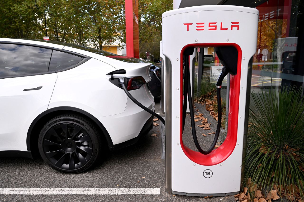 Electric vehicles (EV) line up outside a Tesla dealership.