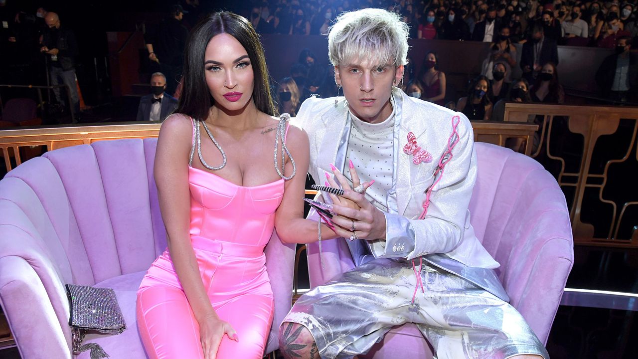 Megan Fox and Machine Gun Kelly on a sofa at an event