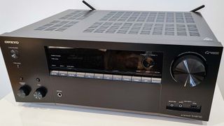 Top down image showing Onkyo TX-NR7100 AV receiver in black on a grey background
